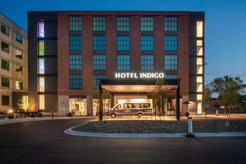 麥迪遜的住宿－Hotel Indigo - Madison Downtown, an IHG Hotel，门前停有面包车的旅馆