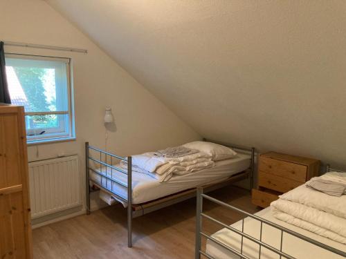 um pequeno quarto com um beliche e uma janela em Karekiet 42 em Oudemirdum