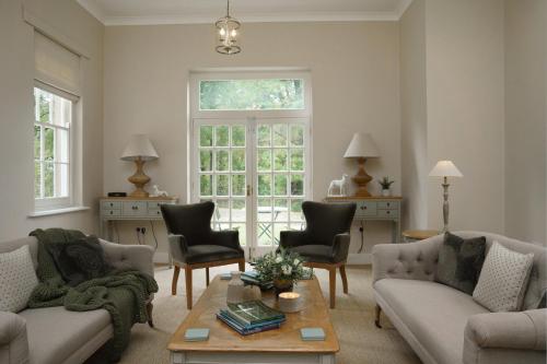 a living room with two couches and a table at Maplewood Cottage, Wynyard Hall in Grindon