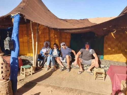 a group of people sitting under a tent at Auberge Kasbah Dar Sahara Tours in Mhamid