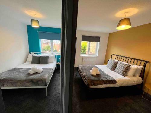 - une chambre avec 2 lits et un canapé dans l'établissement 3 bedroom house with parking, à Manchester