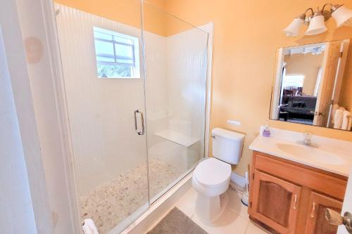 a bathroom with a shower and a toilet and a sink at Chalk Sound Beach Residences Near Sapodilla Bay Beach by Angel Host in Providenciales