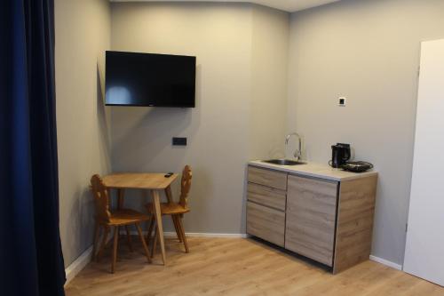 a room with a desk and a table and a sink at ARRIVEL Apartements Heimstetten - bisher Novitel in Kirchheim