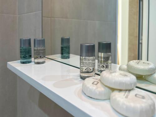 - un comptoir de salle de bains avec des bouteilles de savon dans l'établissement Guest Houses Kapatovo / Къщи за гости КАПАТОВО, 