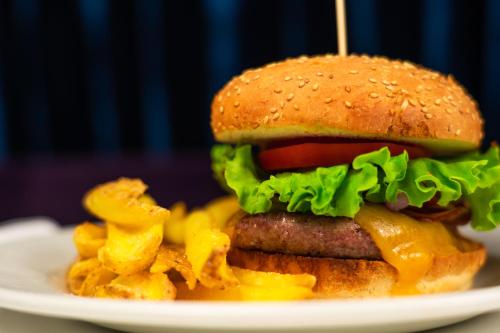 a cheeseburger and french fries on a plate at Emotional Grand Motel in Fontaneto dʼAgogna