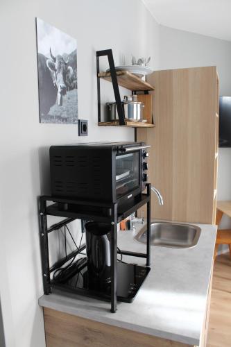 a microwave on a stand in a kitchen at ARRIVEL Apartements Heimstetten - bisher Novitel in Kirchheim