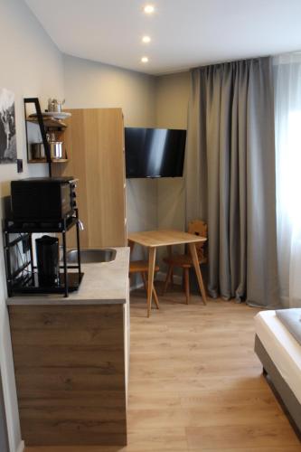 a living room with a desk and a table at ARRIVEL Apartements Heimstetten - bisher Novitel in Kirchheim