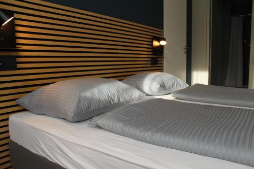 a bed with two white pillows on top of it at ARRIVEL Apartements Heimstetten - bisher Novitel in Kirchheim