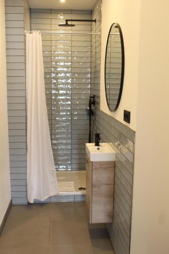 a bathroom with a shower and a sink and a mirror at Novitel Apartements Heimstetten in Kirchheim