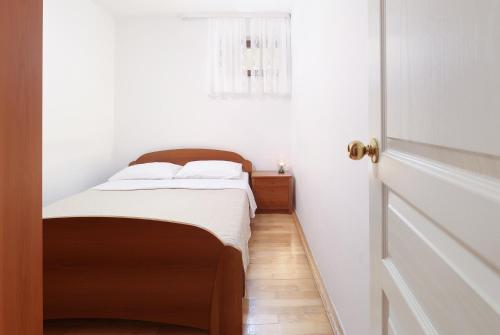 a small bedroom with a bed and a window at Jadranovo Dunja in Jadranovo