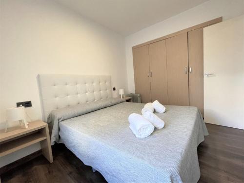 a bedroom with two beds with white towels on them at L&G Apartamentos in Benidorm