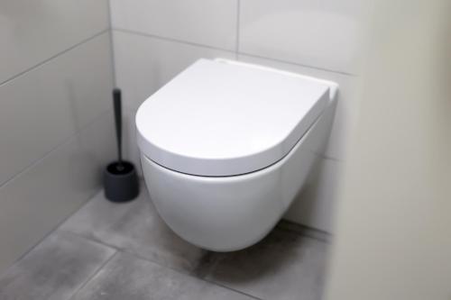 a bathroom with a white toilet in a white wall at Jadranovo Dunja in Jadranovo