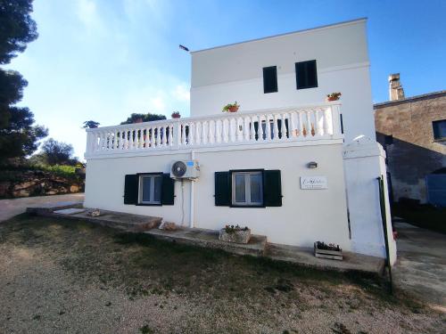 a white house with a balcony on the side of it at La Torlia - Bed & Breakfast in Mottola