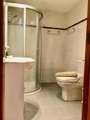 a bathroom with a shower and a toilet and a sink at Cozy Waterman beach house in Costa Teguise