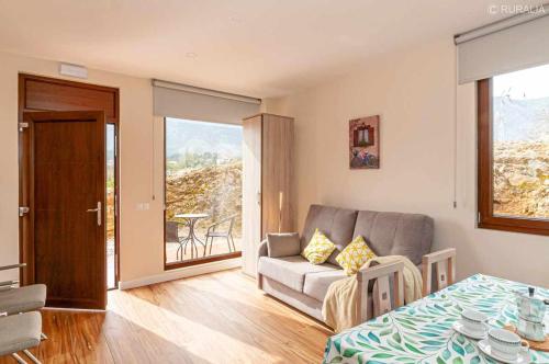 ein Wohnzimmer mit einem Sofa und einem Tisch in der Unterkunft Precioso apartamento cerca de playas y Picos de Europa Apto Reno Rexidora in Cuerres