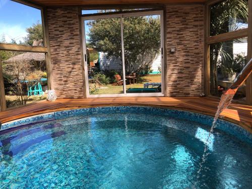 a swimming pool in a house with a large window at Posada Agua Marina in La Paloma