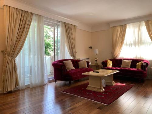 een woonkamer met twee rode banken en een tafel bij Lovely 3 bedroom apartment in Londen