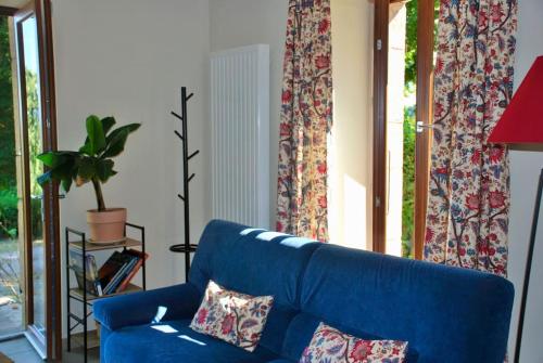a blue couch in a living room with a window at Maison de la Tour in Étang-sur-Arroux