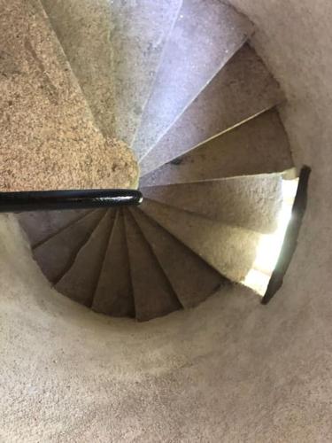 a view from the top of a stairwell with sunlight shining through the ceiling at Maison de la Tour in Étang-sur-Arroux