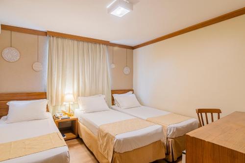 Cette chambre comprend 2 lits et une table. dans l'établissement Carppa Hotel, à Fortaleza