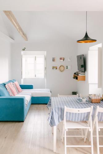 a living room with a blue couch and a table at Casa Ver o Mar in São Mateus