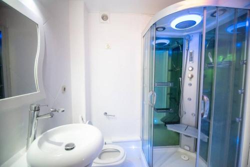 a bathroom with a toilet and a glass shower at PASHA - Ocean view in Sainte-Anne