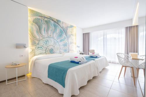 a bedroom with a large bed with a blue and white blanket at Gran Hotel Las Fuentes de Fantasía Hoteles in Alcossebre