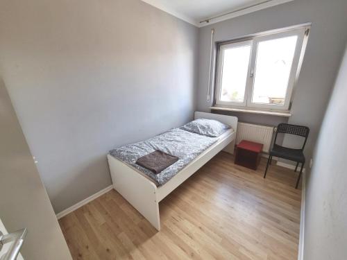 a small bedroom with a bed and a chair at Monteurunterkunft Cadolzburg in Cadolzburg