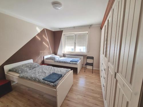 a small room with two beds and a window at Monteurunterkunft Cadolzburg in Cadolzburg