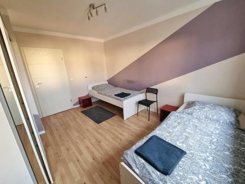 ein Schlafzimmer im Dachgeschoss mit 2 Betten und einem Stuhl in der Unterkunft Monteurunterkunft Cadolzburg in Cadolzburg