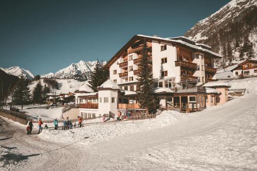 un grupo de personas de pie en la nieve frente a un edificio en Familienhotel Replerhof mit Kinderbetreuung, en Prägraten am Großvenediger