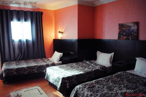 una camera d'albergo con due letti e una finestra di Marrakech Hôtel Résidence a Marrakech
