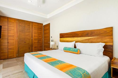 1 dormitorio con 1 cama grande y cabecero de madera en Blue Horizon 901, en Puerto Vallarta