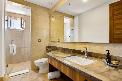 y baño con lavabo, aseo y espejo. en Blue Horizon 901, en Puerto Vallarta