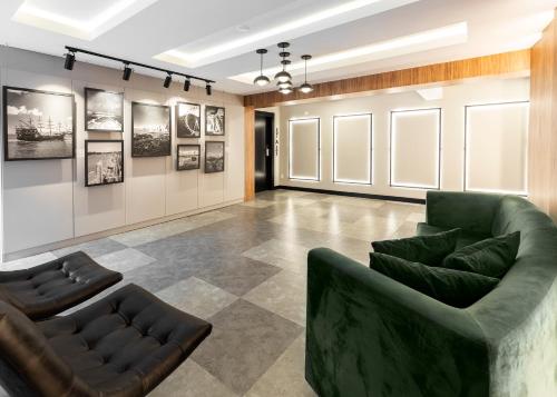 a living room with a green couch and chairs at Hotel Sibara SPA & Convenções in Balneário Camboriú