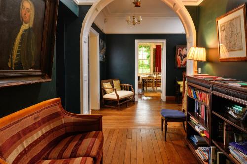 een woonkamer met een bank en een boog bij Finest Retreats - Edwardian Country House - 9 Bed, Sleeping up to 21 in Longtown
