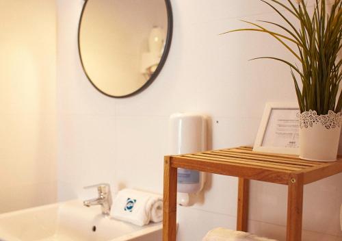 łazienka z lustrem i rośliną na stole w obiekcie ISA Sevilla Suites w Sewilli