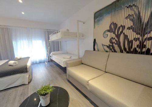 ISA Sevilla Suites في إشبيلية: غرفة معيشة مع أريكة وسرير