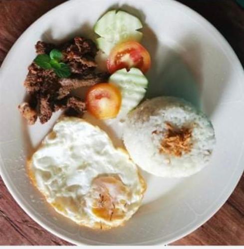 a plate of food with eggs and fruit on it at Nine Balconies Island Stay in Boac
