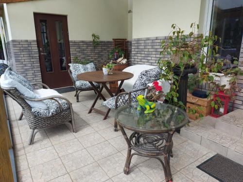 a patio with chairs and a table and a table and chairs at Steam Sauna Apartments in Gargždai