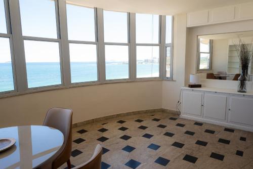 a room with a table and chairs and windows at Bela Vista Copacabana in Rio de Janeiro