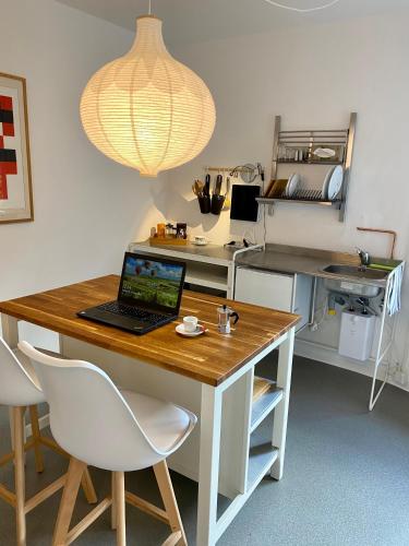 a kitchen with a table with a laptop on it at Kläve12 Guesthouse in Oldenburg