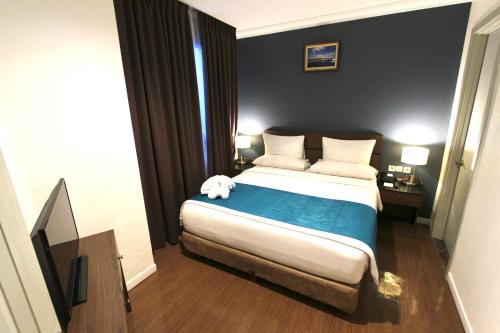 a bedroom with a bed with a teddy bear on it at Forbis Hotel in Serang