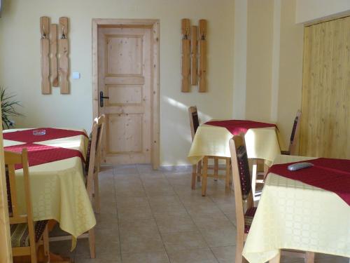 un comedor con mesas y sillas y una puerta en House Arirang, en Cherni Osŭm