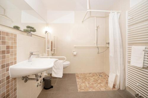 y baño blanco con lavabo y ducha. en Lieblingshafen, en Grömitz