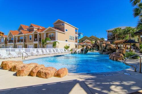 a swimming pool at a resort with chairs and a water slide at Flip Flops & Pop Tops in Port Aransas