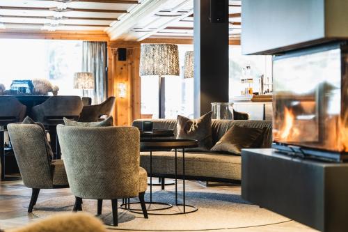a living room with a couch and a table and chairs at Wellness Hotel Alpenhof in Zermatt