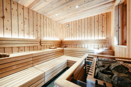a sauna with wooden paneled walls and a tub at Wellness Hotel Alpenhof in Zermatt
