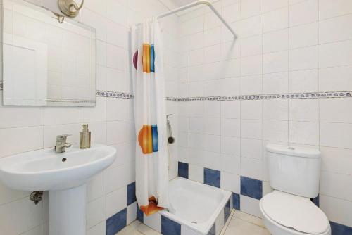 a bathroom with a toilet a sink and a shower at Villa As Cumadres in Azeitao