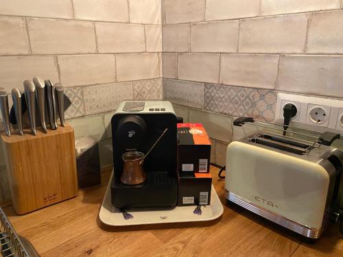 a kitchen counter with a coffee maker and a toaster at Kiskovász Pajta & Inn in Nagytevel